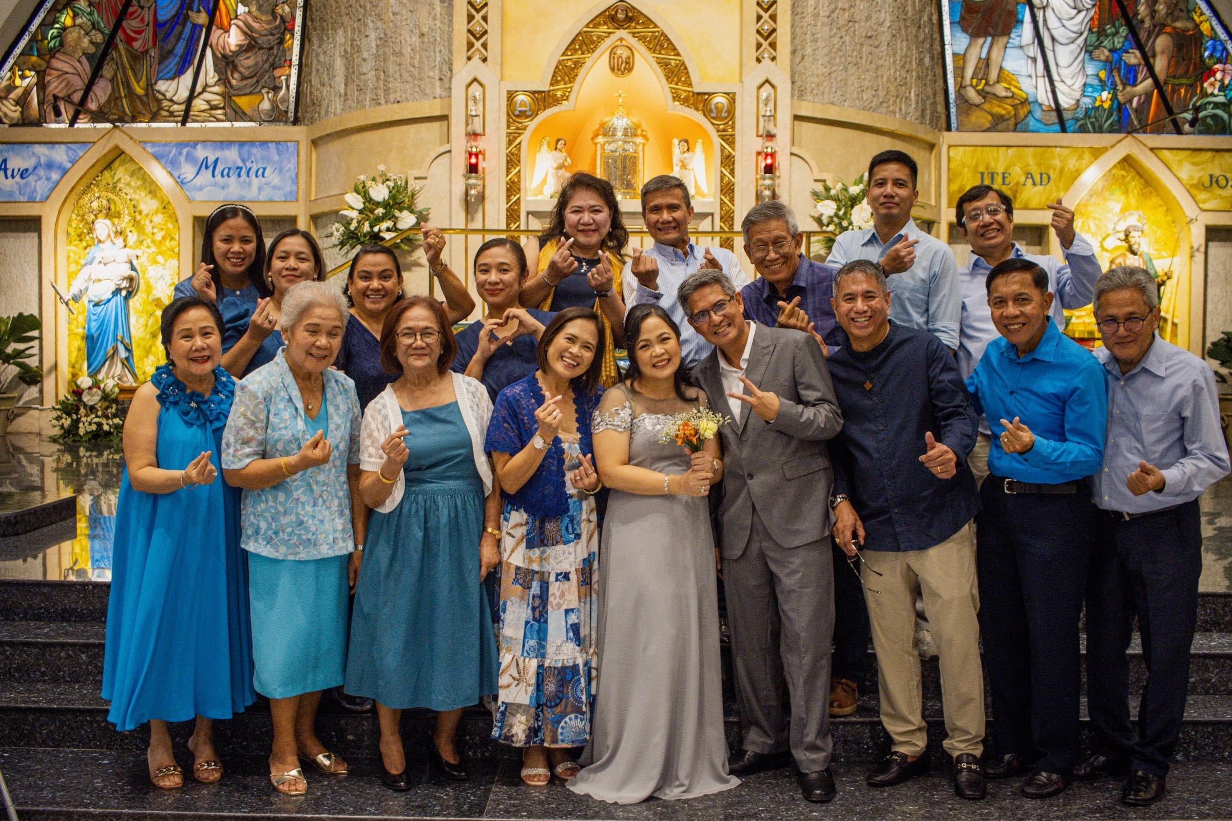 A family gathering poses together in front of a gilded church altar