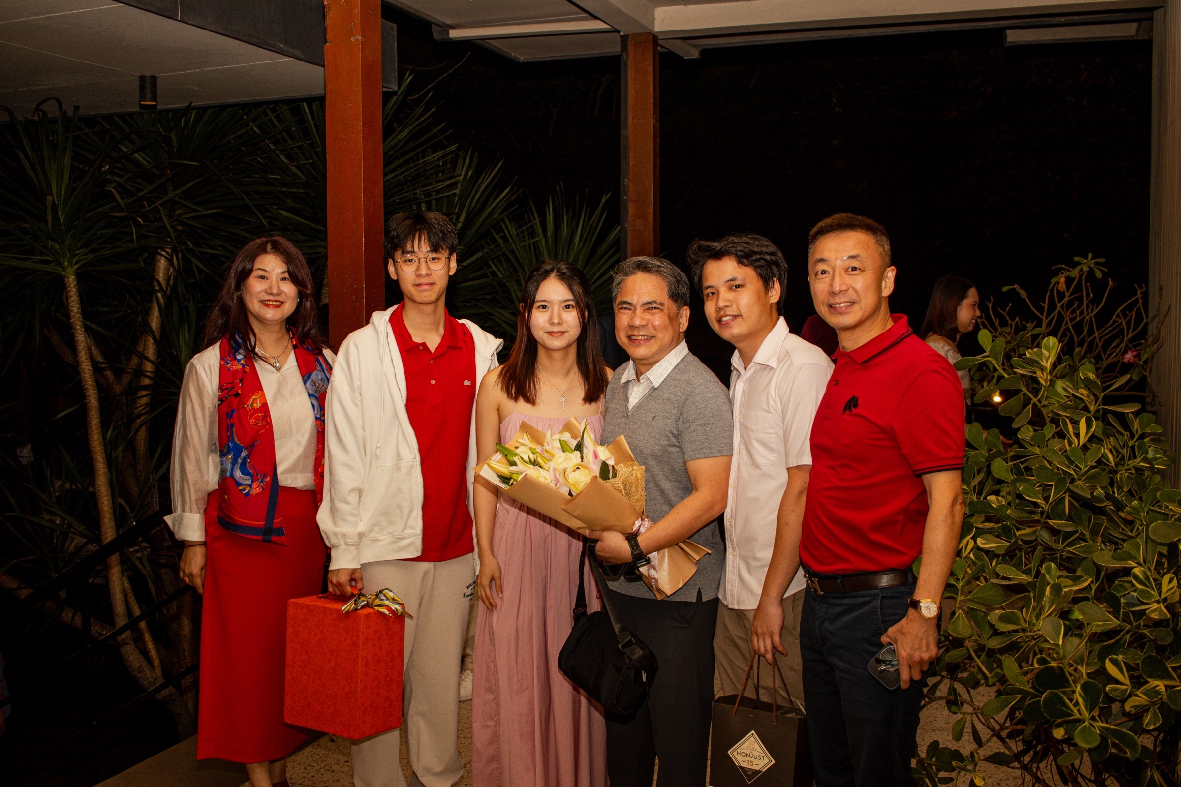 A family arrives at night with gifts and a bouquet